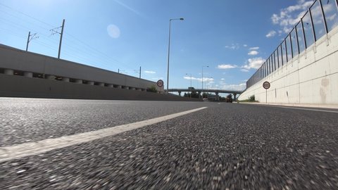 Fast moving video of attiki odos road with clear blue skies taken by stabilised camera attached to motorcycle as seen from asphalt road perspective, Attica, Greece