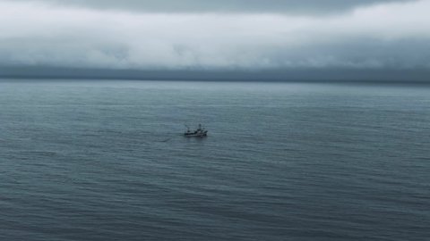 Fishing Trawler Heads Out On The Sea To Catch Fish At Early Morning. Fisherman Boat On St Lawrence River In Quebec, Canada. - aerial drone shot
