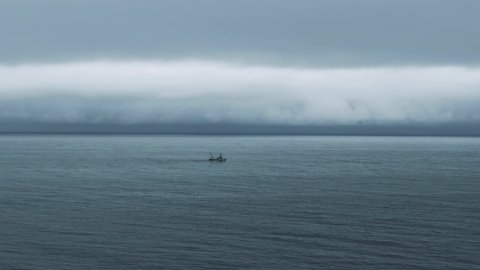 Fishing Boat Sailing At The Saint Lawrence River On A Gloomy Day In Quebec, Canada. - aerial drone shot