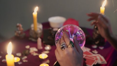 Close up of fortune teller performing ritual and crystal ball foreseeing future