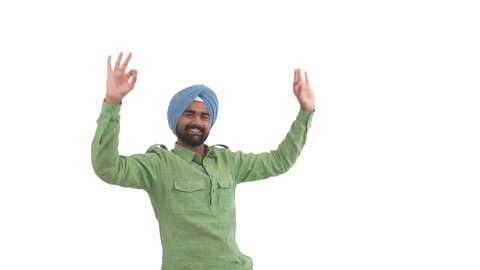 Satisfied Indian beard man raising up hands, making OK sign, lifting shoulders up and putting its down in dancing moves. Isolated on white background
