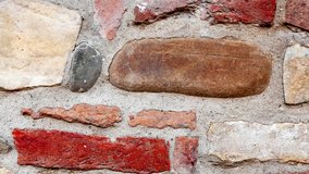 Detail of the typical wall of an old Italian rural house, made with natural river stones, carved and worked by hand.