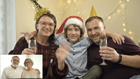 Young family congratulates their elderly parents who live far away, Merry Christmas. Modern technologies. Family video call concept.