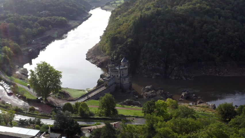 Beautiful Saint-Priest-la-Roche castle in Roanne, France. Aerial view of the historical chateau building ft. sun and lens flare with flying around along the river and nature in HD and 4K