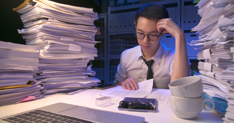 Busy asian business man working multi tasking, talking phone, using laptop, doing paperwork. Tired alone male have a headache while working hard overload at late night.Time lapse, Fast speed shot. Royalty-Free Stock Footage #1060390103