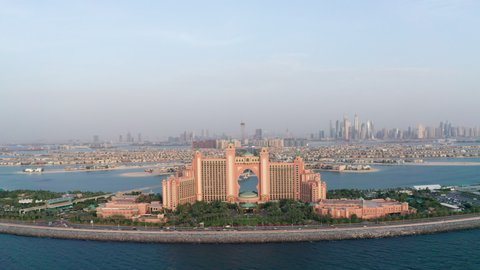 Aerial view of Atlantis hotel and roads leading to Palm Jumeirah man-made islands located on the coast of Dubai, UAE with Dubai Marina skyline in background