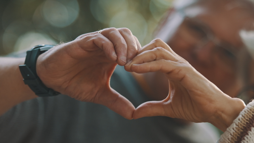 Older retired couple making heart with their hands. Selective focus. High quality 4k footage Royalty-Free Stock Footage #1060391597