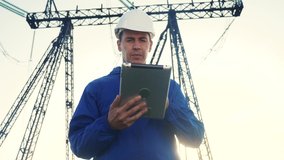worker electrical engineer in helmet a working with digital tablet, near tower with electricity. business energy technology industry concept. electrical studying reading power documents on tablet - Powered by Shutterstock - Get 15% off with code: PIKWIZARD15