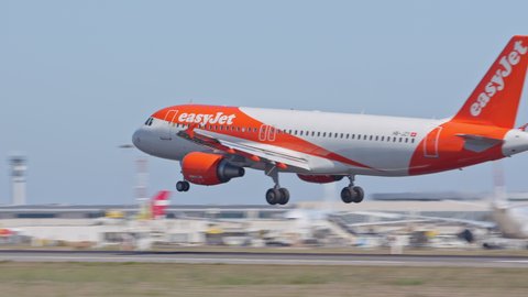 LISBON, PORTUGAL - 2020: EasyJet Airbus A320 Jet Airliner Landing on Runway Arriving at Lisbon Portugal Humberto Delgado Portela LIS International Airport Touching Down with Tire Smoke on a Sunny Day