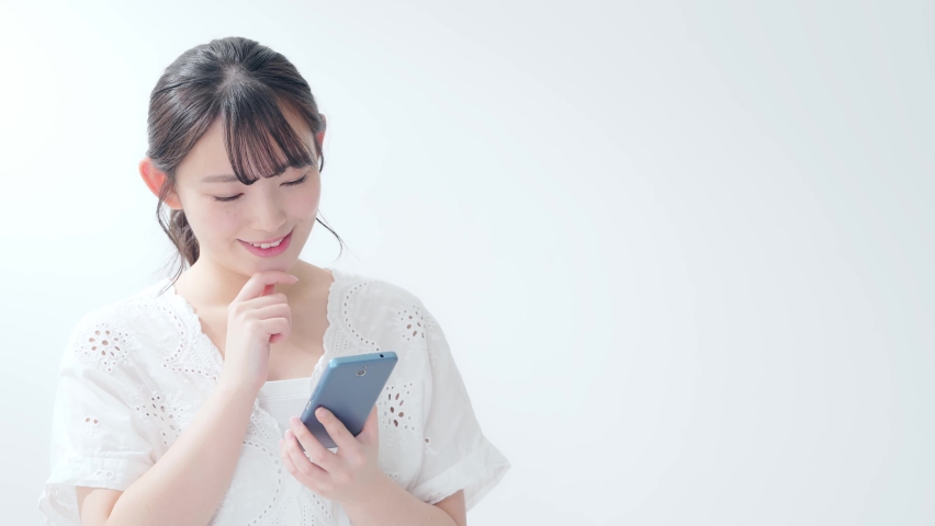 Young asian woman using a smartphone. Royalty-Free Stock Footage #1060404539