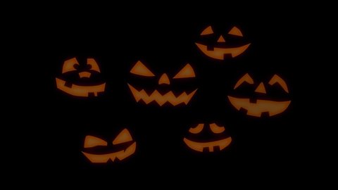 Halloween glowing pumpkins with black background. Orange glow light inside of carved pumpkin heads. Dark smile faces.