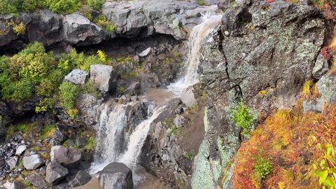 Close-up aerial view of a two-stage waterfall. Stunning autumn landscape. Beautiful place. Travel to the Kamchatka Peninsula.