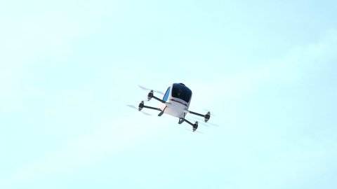 Electric Passenger Drone flying in front of buildings. This is a 3D model and doesn't exist in real life. 3D animation