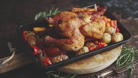 Whole roasted chicken or turkey with pumpkin, potatoes, red pepper and rosemary. Served in metal baking dish.