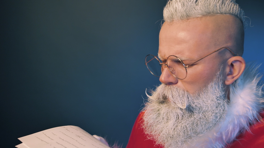 Surprised Reaction of Santa Claus Reading Wishes Letter using lantern lights, Checking Gift List of Kids Dreams Closeup Indoors. Festive Magic, Christmas Spirit, Traditional Preparing Before New Years Eve, Holidays Season