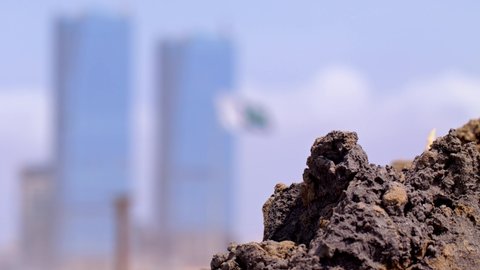 Camera focuses on the National flag of Pakistan as it takes the wind and wave with grace in front of modern buildings Karachi.