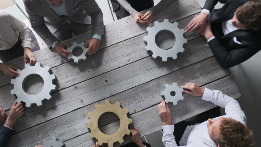 Group of business people joining together silver and golden colored gears on table at workplace teamwork concept Royalty-Free Stock Footage #1060420975