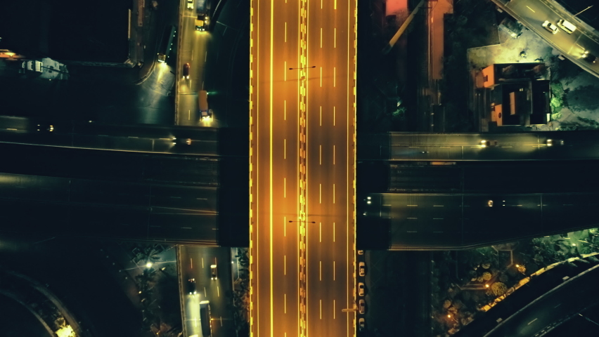 Top down city illuminate roadway at night cityscape aerial view. Beautiful light trails on crossroads at twilight time in Philippines, Manila town. Asia highway with lanterns lit. Cinematic drone shot