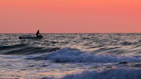 Ocean sunrise. Fisherman sailing with boat on ripple waves