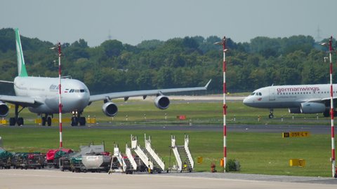 DUSSELDORF, GERMANY - JULY 22, 2017: Mahan Air Airbus 340 EP-MMT taxiing before departure. Germanwings Airbus A319 in the back ground. Dusseldorf airport