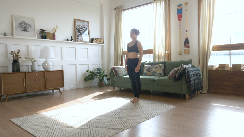 Young Woman doing balance exercise and Stretching sports Yoga, Black Sportswear Leggings and Top, bright room At home in the Morning. Royalty-Free Stock Footage #1060427782