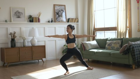 Young Woman Doing Meditation Exercise Stretching Sports Yoga, Clothes Black Leggings and tube Top, Bright Room at Home.