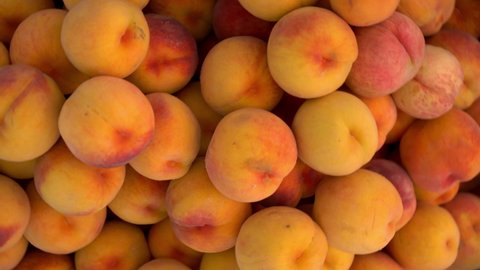 Close-up of many peaches on the market. The camera turns and zooms in.