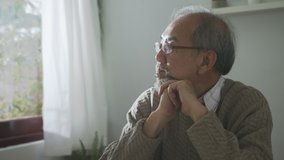 Close up : Sad old retired gray haired grandpa asian man sitting alone at table desk at window boring stay home self isolation quarantine feeling depress in problem mental health. - Powered by Shutterstock - Get 15% off with code: PIKWIZARD15