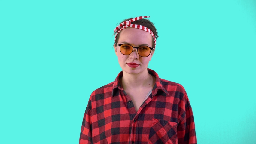 Stylish and Fashionable Pin-up style Housewife in hipster glasses with a pollinator in her hands. Household chores concept, housekeeper.