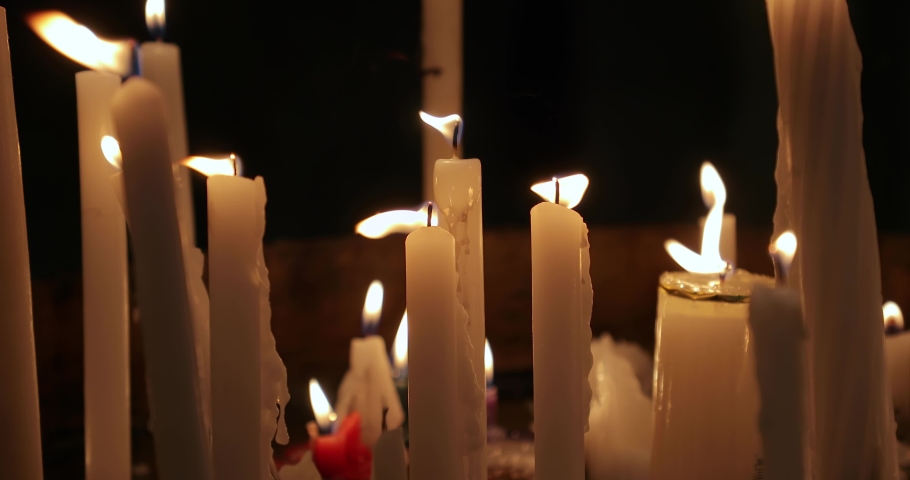 Candles burning on a church altar in dim light Royalty-Free Stock Footage #1060435279