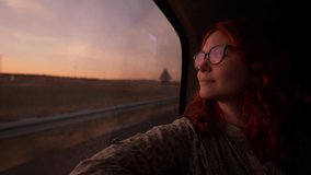 young redhead woman traveling by car at sunset, road trip, automobile travel, driving car in the countryside. High quality footage - Powered by Shutterstock - Get 15% off with code: PIKWIZARD15