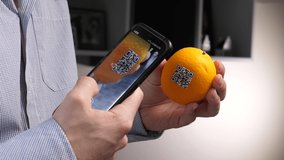 Scanning an orange with a QR code using a smartphone device. - Powered by Shutterstock - Get 15% off with code: PIKWIZARD15