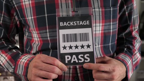 Wearing a backstage pass at a concert to have access to the backstage of the scene.