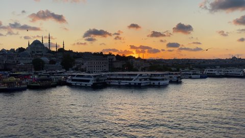 Slow Tilt up revealing Golden Horn Bosphorus and Istanbul Cityscape in Beautiful Sunsets with Mosque and Boats, Seagulls Flying By, ISTANBUL, TURKEY, SEPTEMBER 16th 2020