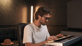 Young stylish music producer listening song from new album enjoy work in modern sound recording studio