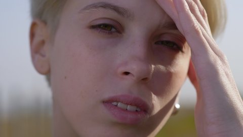 androgynous model portrait, close up of a blonde young lesbian woman. High quality 4k footage