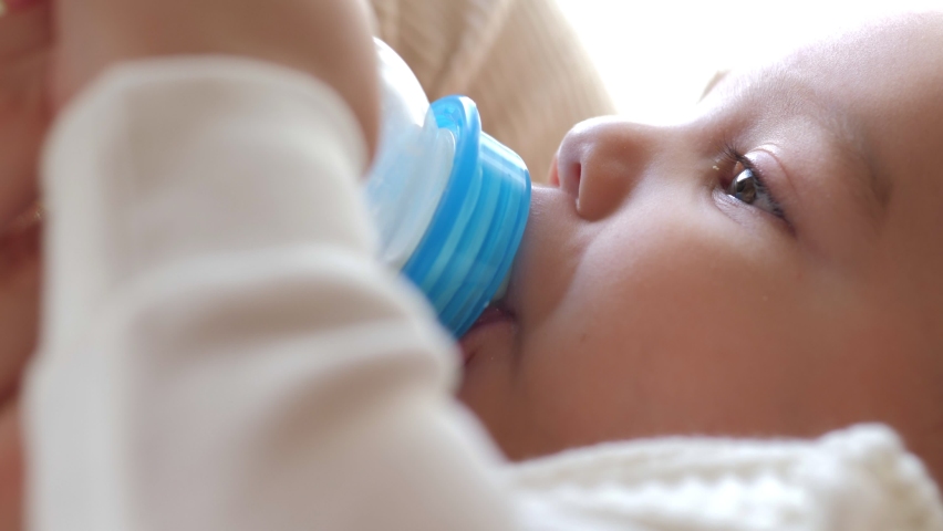 Closeup view of mother feeding her baby milk from bottle Royalty-Free Stock Footage #1060439587