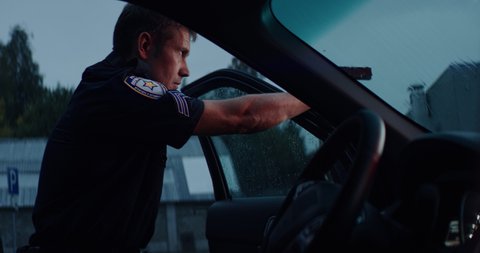 HANDHELD Police officer hiding behind the door and aiming handgun at someone in the street. Shot on RED Dragon with 2x Anamorphic lens