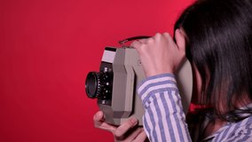 A beautiful girl making video shooting with a retro camera. Shoot over and the operator is feeling happy