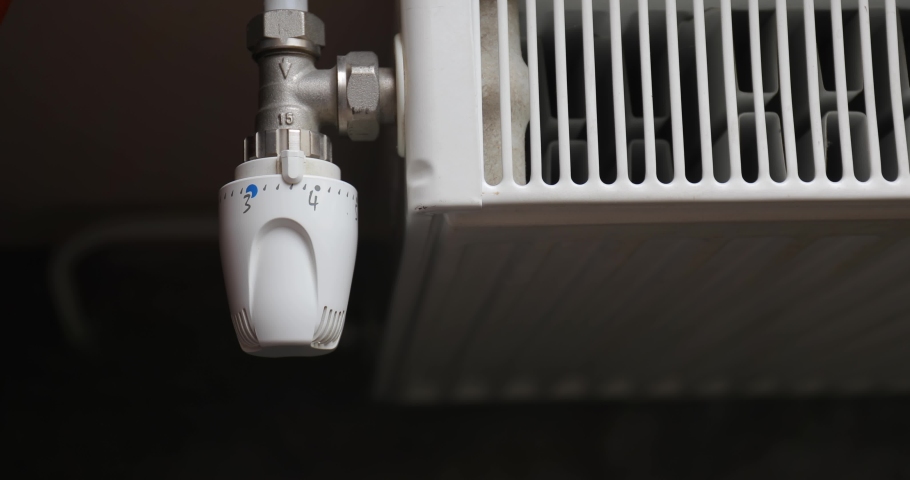 Turning down the heating adjusting radiator valve in a room Royalty-Free Stock Footage #1060446655