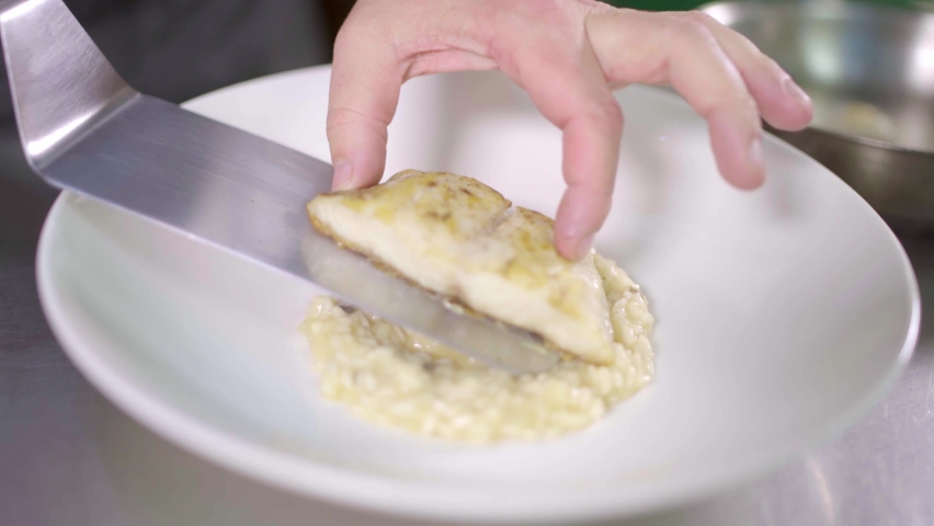 Placing red snapper loin sobre risotto
