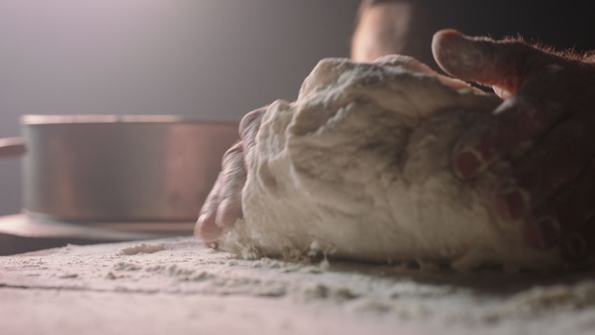 Closeup shot of hands of senior bakery chef applying flour on dough, old man kneading dough, making bread using traditional recipe, isolated on black background 4k footage | Shutterstock HD Video #1060453330