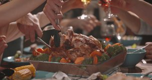 Close up shot of people eating delicious roasted turkey during thanksgiving or christmas dinner party, filling up plates and glasses - food and drink, celebration 4k footage