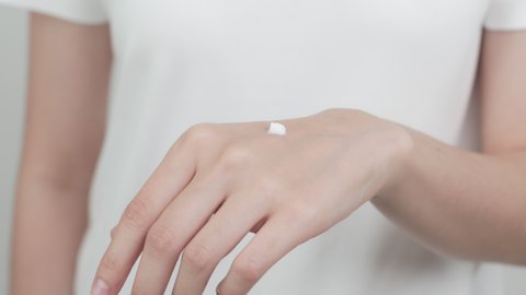 Close up of woman hand holding and applying moisturiser, Body lotion, isolated on white background.
