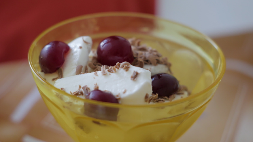 Ice Cream With Chocolate and Cherry Closeup. Yummy Sweet Food Dessert Delicious Close Up. Curd Dessert With Chocolate Chips and Cherry in Cup.