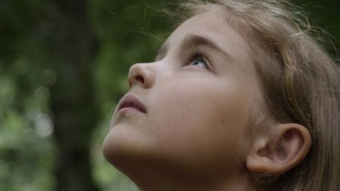 Kid Looking Up at Sky in Nature. Portrait Little Girl Praying Looking Up at Sky With Hope and Faith, Contemplative Child Face, Closeup. Girl Looks-up God Believer Prayer, Passionate Dreamer Divine.