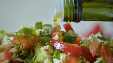 Vegetable Fresh Salad Food Healthy Meal Mediterranean Kitchen Vegetarian Diet Olive Oil. Closeup Pour Olive Oil on Fresh Salad. Close up Healthy Lunch, Colorful Food Onion Cucumber Radish. Slow Motion