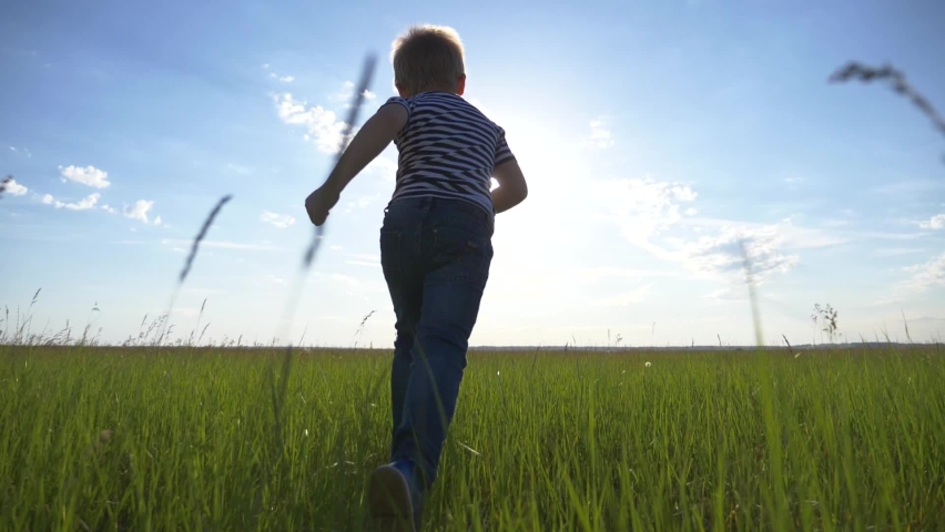 Happy child in the park. Silhouette  run child at sunset. Happy child run across the field in the park. Kid is dreaming. Silhouette of a run happy kid. KId dreams of becoming an airplane pilot. Royalty-Free Stock Footage #1060463596