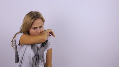 The woman coughs correctly on the elbow. Strong cough during illness