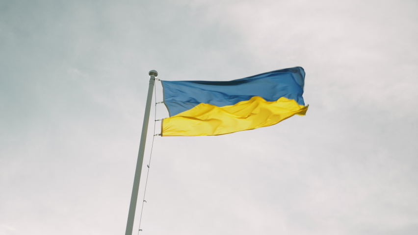 Ukraine national flag is waving in wind against cloudy sky. Flag of Ukraine on flagpole is flapping in wind Royalty-Free Stock Footage #1060466401